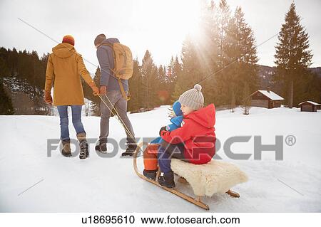 Rear view of parents pulling sons on toboggan in snow landscape, Elmau, Bavaria, Germany View Large Photo Image Stock Image - Rear view of parents pulling sons on toboggan in snow landscape, Elmau, Bavaria, Germany. Fotosearch