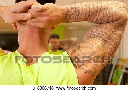 Rear view of tattooed man hands behind head doing stretching exercise View Large Photo Image Stock Photo - Rear view of tattooed man hands behind head doing stretching exercise. Fotosearch
