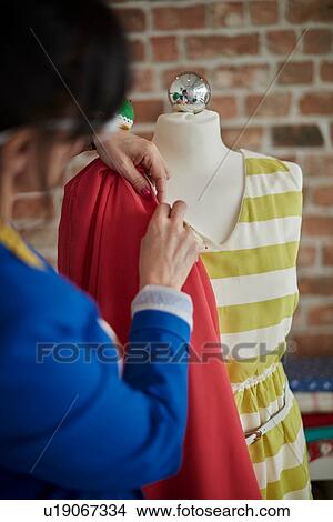 Picture - Rear view of woman in design studio draping fabric onto mannequin. Fotosearch