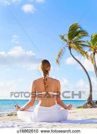 Rear view of young woman practising yoga lotus pose on beach, Dominican Republic, The Caribbean View Large Photo Image Stock Image - Rear view of young woman practising yoga lotus pose on beach, Dominican Republic, The Caribbean. Fotosearch