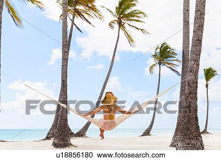 Rear view of young woman sitting on beach hammock, Dominican Republic, The Caribbean View Large Photo Image Stock Image - Rear view of young woman sitting on beach hammock, Dominican Republic, The Caribbean. Fotosearch
