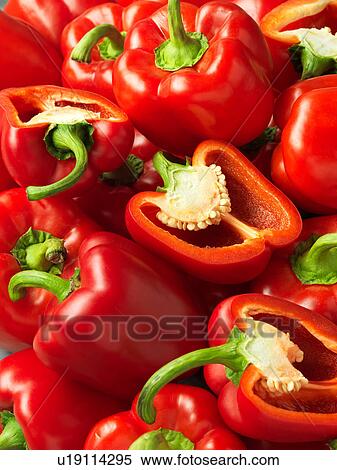 Stock Photography - Red bell peppers, whole and sliced, full frame, close-up. Fotosearch