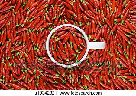Stock Image - Red chilli peppers and white mug. Fotosearch