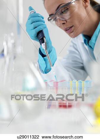 Stock Image - Researcher pipetting liquid. Fotosearch