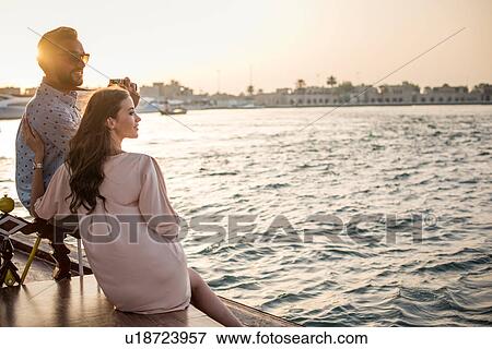 Romantic couple looking out from boat at Dubai marina, United Arab Emirates View Large Photo Image Stock Photo - Romantic couple looking out from boat at Dubai marina, United Arab Emirates. Fotosearch