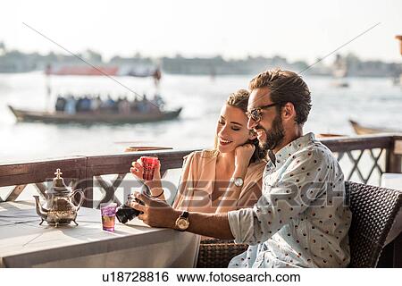 Romantic couple reviewing camera at Dubai marina cafe, United Arab Emirates View Large Photo Image Stock Photograph - Romantic couple reviewing camera at Dubai marina cafe, United Arab Emirates. Fotosearch
