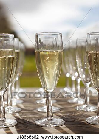 Stock Image - Rows of champagne in champagne flutes. Fotosearch