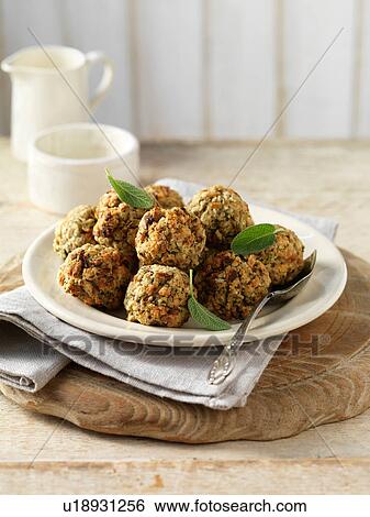 Stock Photograph - Sage and onion stuffing balls, with green herbs on plate. Fotosearch