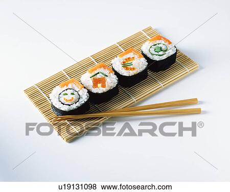 Salmon sushi on placemats with wooden chopsticks View Large Photo Image Stock Photo - Salmon sushi on placemats with wooden chopsticks. Fotosearch