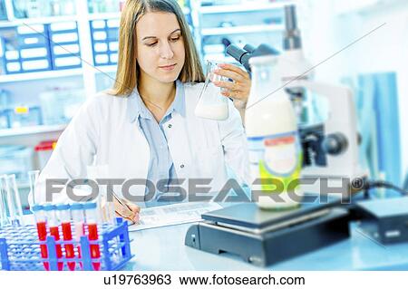 Stock Image - Scientist holding a glass beaker. Fotosearch