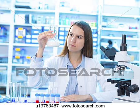 Stock Photo - Scientist holding a glass beaker. Fotosearch