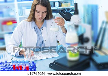 Stock Photograph - Scientist holding a glass beaker. Fotosearch