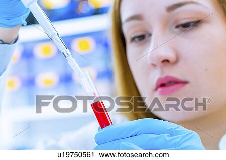 Stock Image - Scientist holding a test tube. Fotosearch