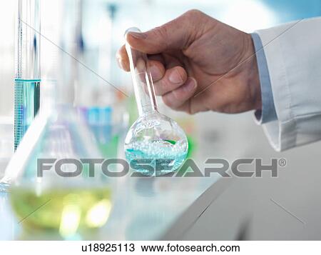 Stock Image - Scientist preparing a chemical formula in a conical flask during an experiment in the laboratory. Fotosearch