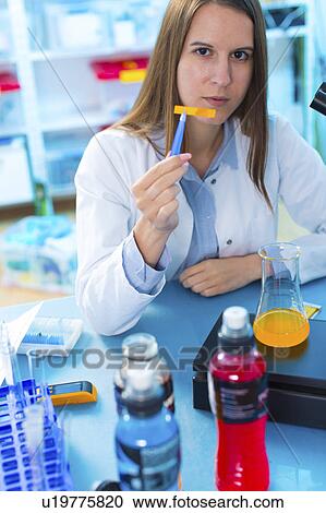 Stock Image - Scientist testing food samples in a flask. Fotosearch