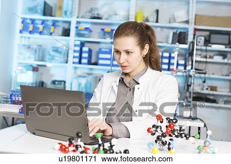 Stock Image - Scientist using laptop in lab. Fotosearch