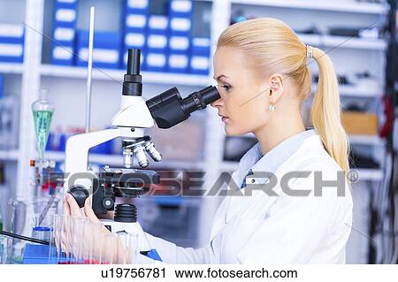 Stock Image - Scientist using microscope. Fotosearch