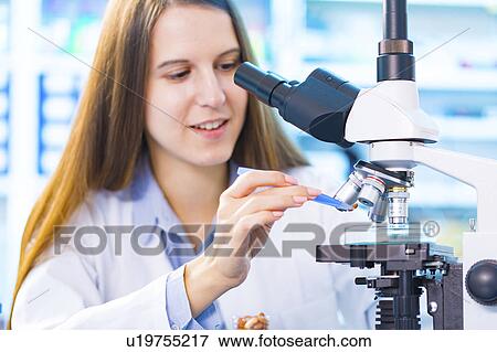 Stock Photo - Scientist using microscope. Fotosearch