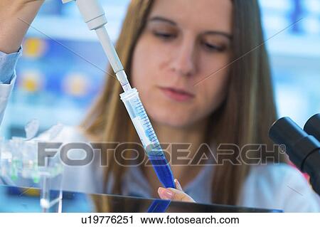 Stock Image - Scientist using pipette and a test tube. Fotosearch