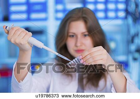 Stock Image - Scientist using pipette and micro tubes. Fotosearch