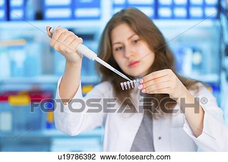 Stock Image - Scientist using pipette and micro tubes. Fotosearch