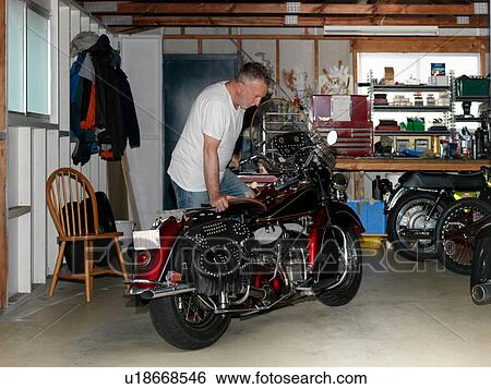 Senior man checking over motorcycle in garage View Large Photo Image Stock Photograph - Senior man checking over motorcycle in garage. Fotosearch