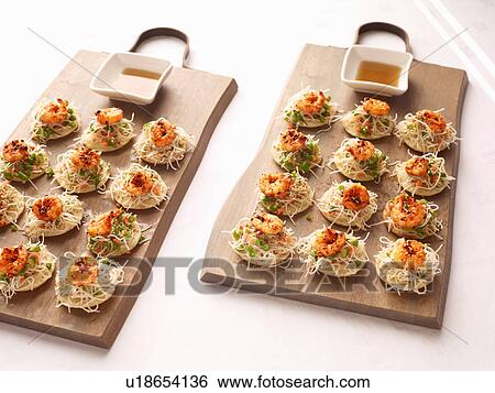 Stock Photograph - Sesame noodles and chilli prawn canapes with dipping sauce. Fotosearch