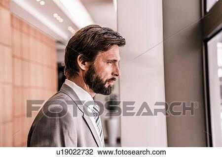 Side view of bearded businessman looking out of window View Large Photo Image Stock Image - Side view of bearded businessman looking out of window. Fotosearch