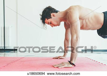 Side view of man in gym doing push ups View Large Photo Image Picture - Side view of man in gym doing push ups. Fotosearch