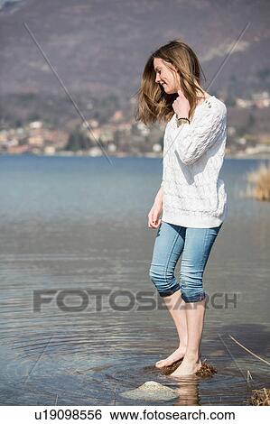 Side view of teenage girl with jeans rolled up ankle deep in water View Large Photo Image Stock Photograph - Side view of teenage girl with jeans rolled up ankle deep in water. Fotosearch