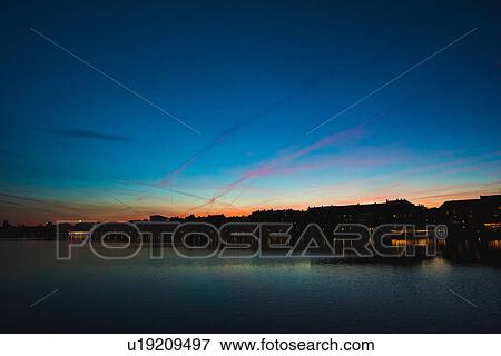 Stock Photo - Silhouetted sunset over river waterfront, Copenhagen, Denmark. Fotosearch