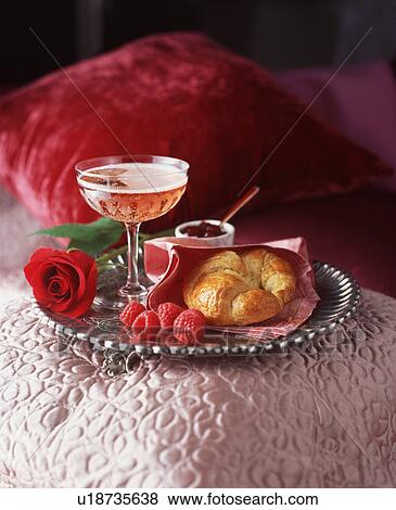 Stock Photo - Silver tray with glass of pink champagne, croissant and raspberries. Fotosearch