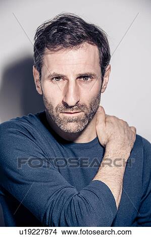 Studio portrait of staring bearded man with hand on his shoulder View Large Photo Image Picture - Studio portrait of staring bearded man with hand on his shoulder. Fotosearch
