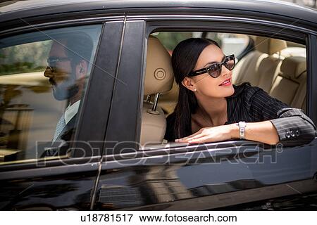 Stylish businesswoman looking back from backseat car window, Dubai, United Arab Emirates View Large Photo Image Stock Photo - Stylish businesswoman looking back from backseat car window, Dubai, United Arab Emirates. Fotosearch