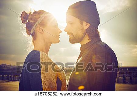 Sunlit portrait of mid adult couple face to face on rooftop parking lot View Large Photo Image Stock Image - Sunlit portrait of mid adult couple face to face on rooftop parking lot. Fotosearch