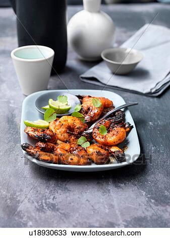 Stock Image - Sweet and smokey chargrilled prawns on plate. Fotosearch