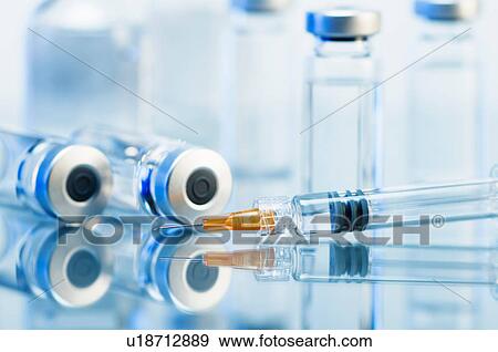 Stock Photo - Syringe. Disposable plastic medical syringe surrounded by sealed medication vials. Fotosearch