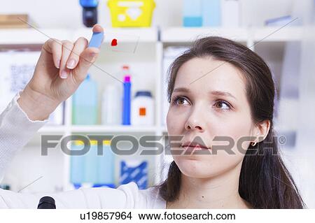 Picture - Technician holding microscope slide. Fotosearch