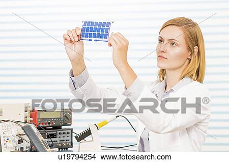 Picture - Technician holding thin film solar cells. Fotosearch