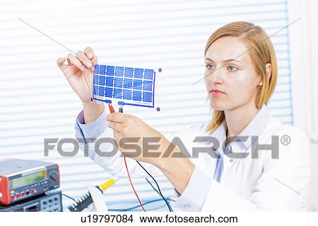 Picture - Technician holding thin film solar cells. Fotosearch