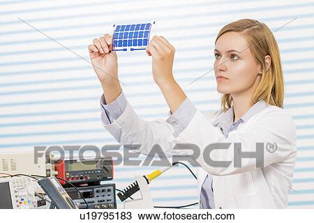 Stock Image - Technician holding thin film solar cells. Fotosearch