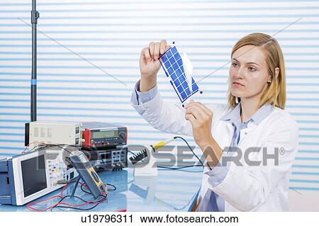 Stock Image - Technician holding thin film solar cells. Fotosearch