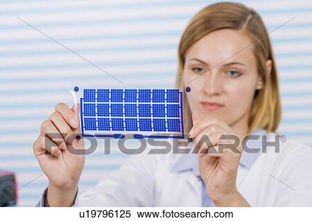 Stock Photography - Technician holding thin film solar cells. Fotosearch