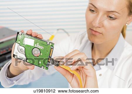 Stock Image - Technician repairing circuit board. Fotosearch