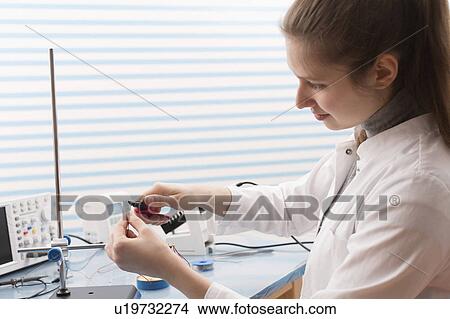 Technician soldering wires in lab View Large Photo Image Picture - Technician soldering wires in lab. Fotosearch