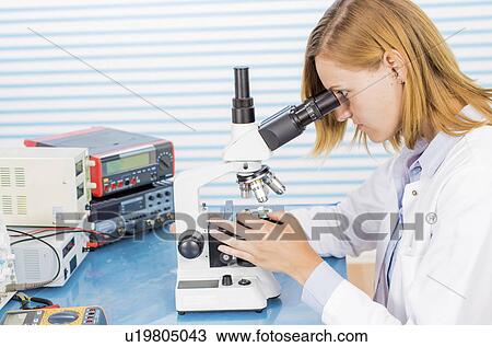 Stock Image - Technician with microscope, portrait. Fotosearch