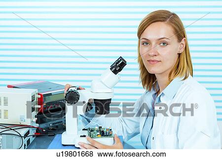 Stock Photo - Technician with microscope, portrait. Fotosearch