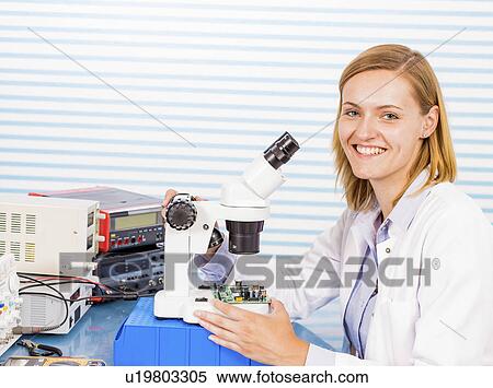 Stock Photography - Technician with microscope, portrait. Fotosearch