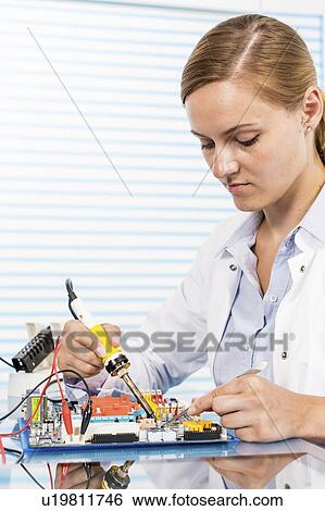 Technician working on a circuit board View Large Photo Image Stock Photograph - Technician working on a circuit board. Fotosearch