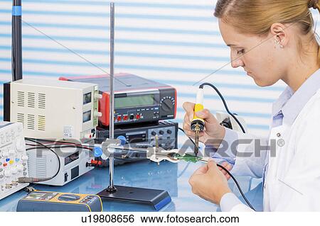Stock Photograph - Technician working on circuit board. Fotosearch